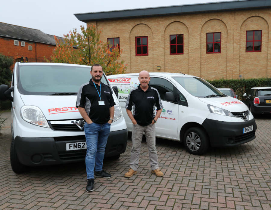 Pestforce franchise two franchisee workers standing proudly with their vans